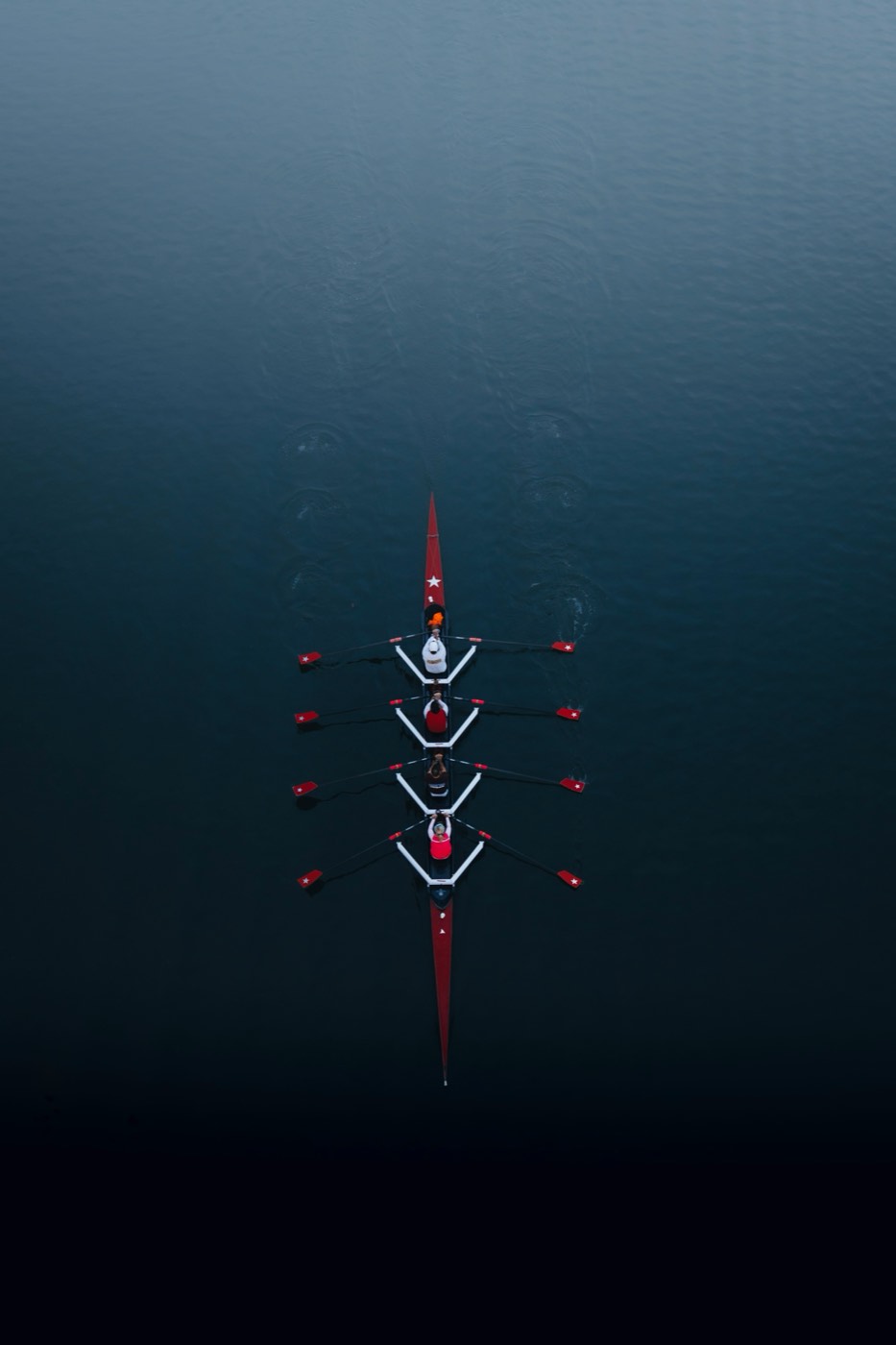 Rowing crew seen from above on calm water