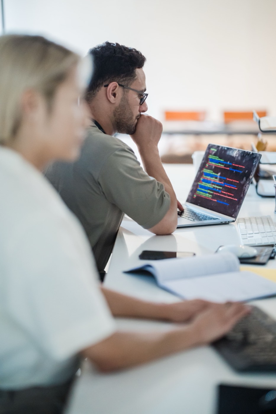 A developer working focused at a desk with multiple screens