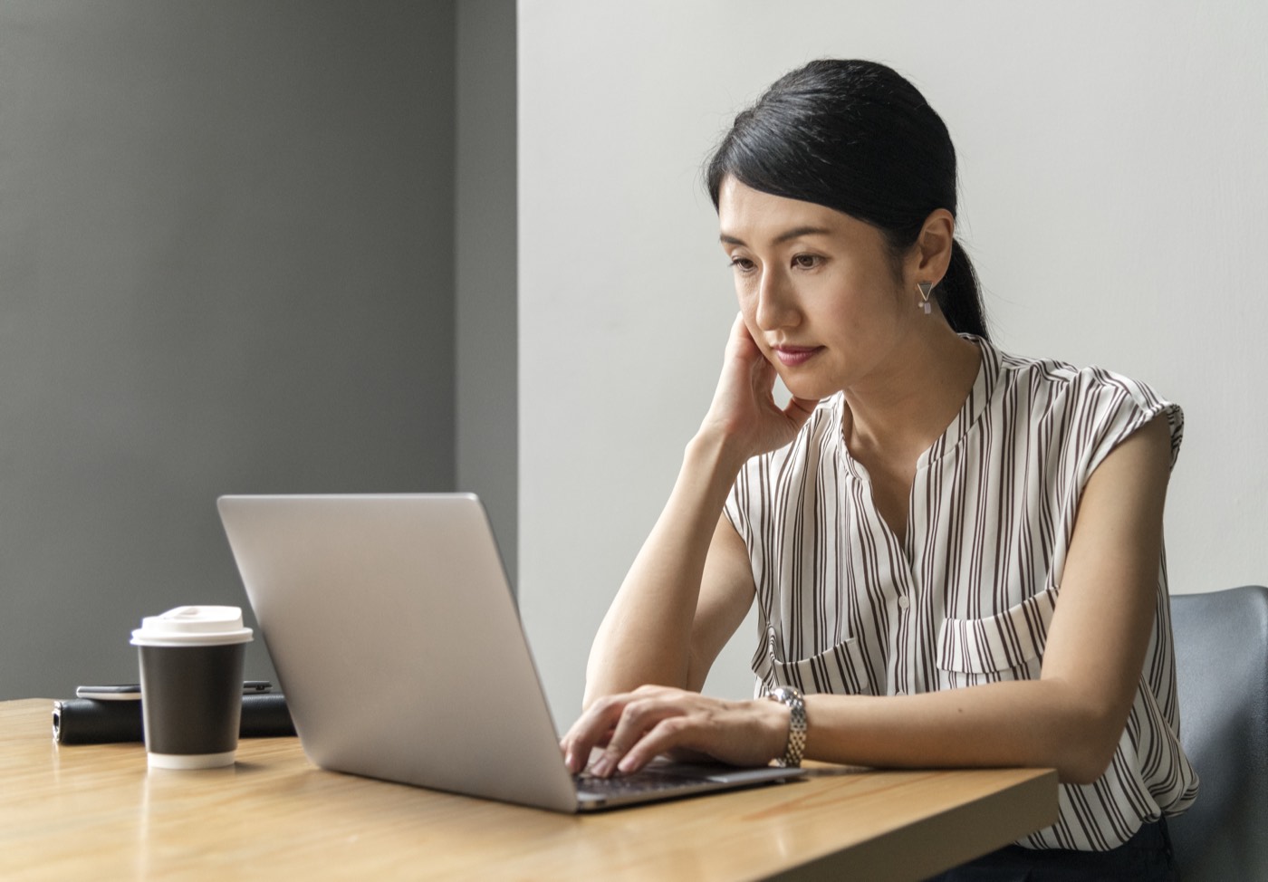 A woman calmly reading her laptop screen