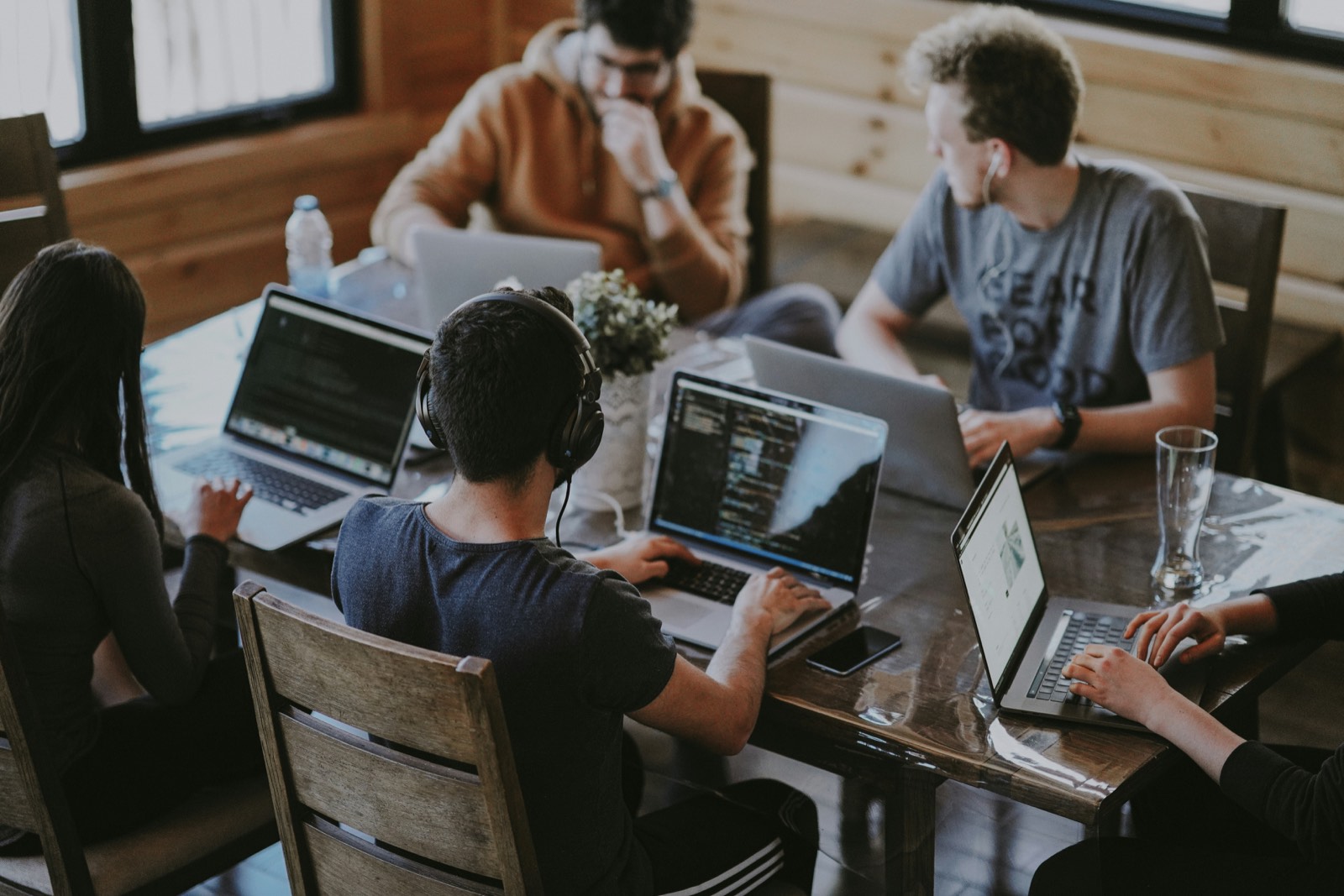 A team working together around a table full of laptops
